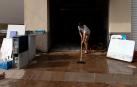 Una mujer limpia su vivienda tras las lluvias en Tarragona