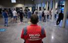 Un agente de la Policía Foral, junto a los aspirantes, en la entrada al Aulario de la UPNA.