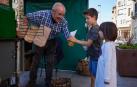 El castañero entrega un cucurucho de castañas a dos niños