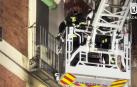 El camión escala de los bomberos trabaja en la fachada del inmueble que se incendió