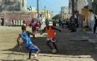 En una calle de Saint Louis, al norte de Senegal, un joven trata de zafarse de su defensor en un improvisado encuentro de fútbol