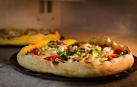 Un horno de piedra con dos pizzas