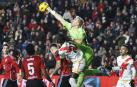 El meta del Celta, Guaita, despeja de puños saltando más que los rivales en una jugada dle partido./