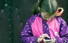Una niña con un móvil en un recreo