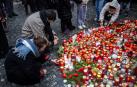 Varias personas encienden velas en la Universidad Carolina de Praga, donde tuvo lugar el tiroteo este 21 de diciembre