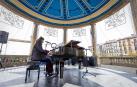 Fotos de personas tocando el piano de cola instalado en el kiosco de la Plaza del Castillo de Pamplona. /