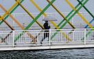 Una mujer con paraguas atraviesa el puente de San Sebastián en Avilés este martes lluvioso