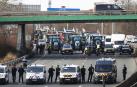 Agentes de policía vigilan decenas de tractores que participan en una manifestación en la autopista A15 cerca de Argenteuil, al norte de París