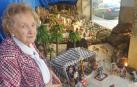 Elena Ciordia posa junto al belén que montan en el escaparte de su tienda en Burlada
