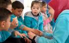 ALEPO, FEBRERO DE 2023. Una de las educadoras de los Maristas Azules anuda una de las 150 pulseras enviadas desde Navarra semanas después del terremoto.
