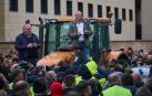 Salvador Moreno, con camisa blanca, encima de un tractor tras la reunión en el departamento de Desarrollo Rural