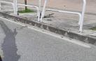 Una de la valla afectada tras la colisión y restos del vehículo tras el accidente.