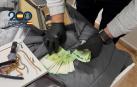 Un agente de la Policía Nacional cuenta dinero incautado y joyas durante la operación contra la banda que asaltaba viviendas de lujo en Madrid./