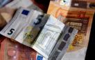 Varios billetes con uno de 5 euros en primer plano