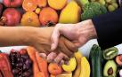 Dos personas estrechan la mano tras alcanzar un acuerdo en un supermercado./