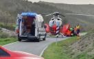 Agentes de la Policía Foral junto al helicóptero que trasladó a uno de los motoristas accdentados este domingo./