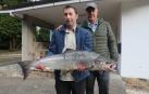 Gonzalo Díaz Soto (i), pescador de Cangas de Narcea, que posa junto a su ganchero. El ejemplar ha pesado 8,2 kilos y mide 92 centímetros