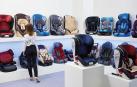 Una mujer observa en una tienda diferentes modelos de sillas de coche para niños