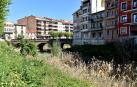 Vista del cauce del río Cidacos, completamente cubierto, con el puente al fondo