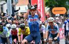 Tim Merlier alza los brazos en la meta de Fossano