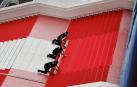 Trabajadores instalan la alfombra roja antes de la ceremonia de apertura del 77º Festival de Cine de Cannes