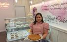 Sandra Patricia Gómez sostiene una tarta lotus en el interior de la tienda que acaba de a brir