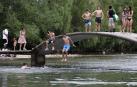 Fotos de los bañistas en el río Arga, junto al Molino de Caparroso, en Pamplona, en una jornada de intenso calor.