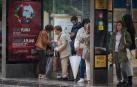 Las marquesinas han sido improvisados refugios este jueves para protegerse de la lluvia