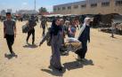 Varios refugiados caminan con sus pertenencias en la localidad de Khan Younis