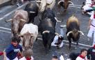 Los mozos corren junto a los morlacos de La Palmosilla en el tramo de la Plaza del Ayuntamiento durante el primer encierro de los Sanfermines 2024