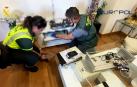 Dos agentes de la Guardia Civil inspeccionan la documentación incautada durante la operación