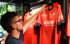 Un aficionado ojea la nueva camiseta de Osasuna, en la tienda de El Sadar