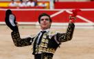 El diestro Jesús Enrique Colombo saluda al tendido tras cortar una oreja a su primer toro de la ganadería Miura durante la última corrida de la Feria del Toro de Pamplona