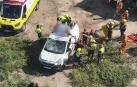 Servicios de emergencia socorren al ciclista, en la baca de la furgoneta