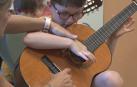 Un niño aprendiendo a tocar la guitarra