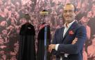El investigador y coordinador general de la Asociación de Amigos de la Universidad de Navarra, Manuel Vilches, junto a las vestes académicas expuestas en el hall de Rectorado