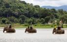 Turistas montados sobre elefantes cruzan el lago Lak, en Vietnam