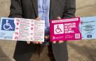 Una persona sujeta tarjetas de aparcamiento de personas con movilidad reducida en Pamplona