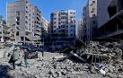 La gente camina entre los escombros de los edificios destruidos después de los ataques aéreos israelíes en el suburbio del sur de Beirut, Líbano, este domingo
