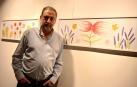 El artista navarro Nacho Barberena posa delante de sus cuadros con flores muy bellas que intentan atraer a las mariposas... a la muerte