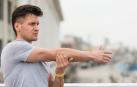 Un joven realiza estiramientos con los brazos