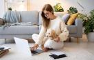 Una joven, con su perro y su ordenador en casa