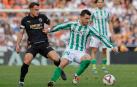 Giovani Lo Celso del Betis lucha por el balón con German Valera del Valencia durante el partido de la jornada 14 de LaLiga disputado este sábado en el estadio de Mestalla
