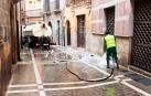 Un empleado municipal pasa la manguera en una calle del Casco Viejo de Pamplona /