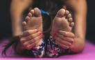 Imagen de los pies de una persona estirando en una esterilla