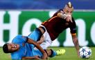 Radja Nainggolan, con la camiseta de la Roma, choca con Luis Suárez en un partido contra el Barcelona de Champions League en 2015