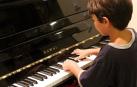 Un niño aprendiendo a tocar el piano