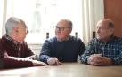 Un grupo de personas mayores hablando en una mesa
