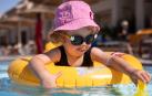 Una niña con gafas de sol en la piscina