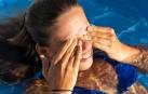 Una niña se rasca los ojos en una piscina, en una imagen de archivo